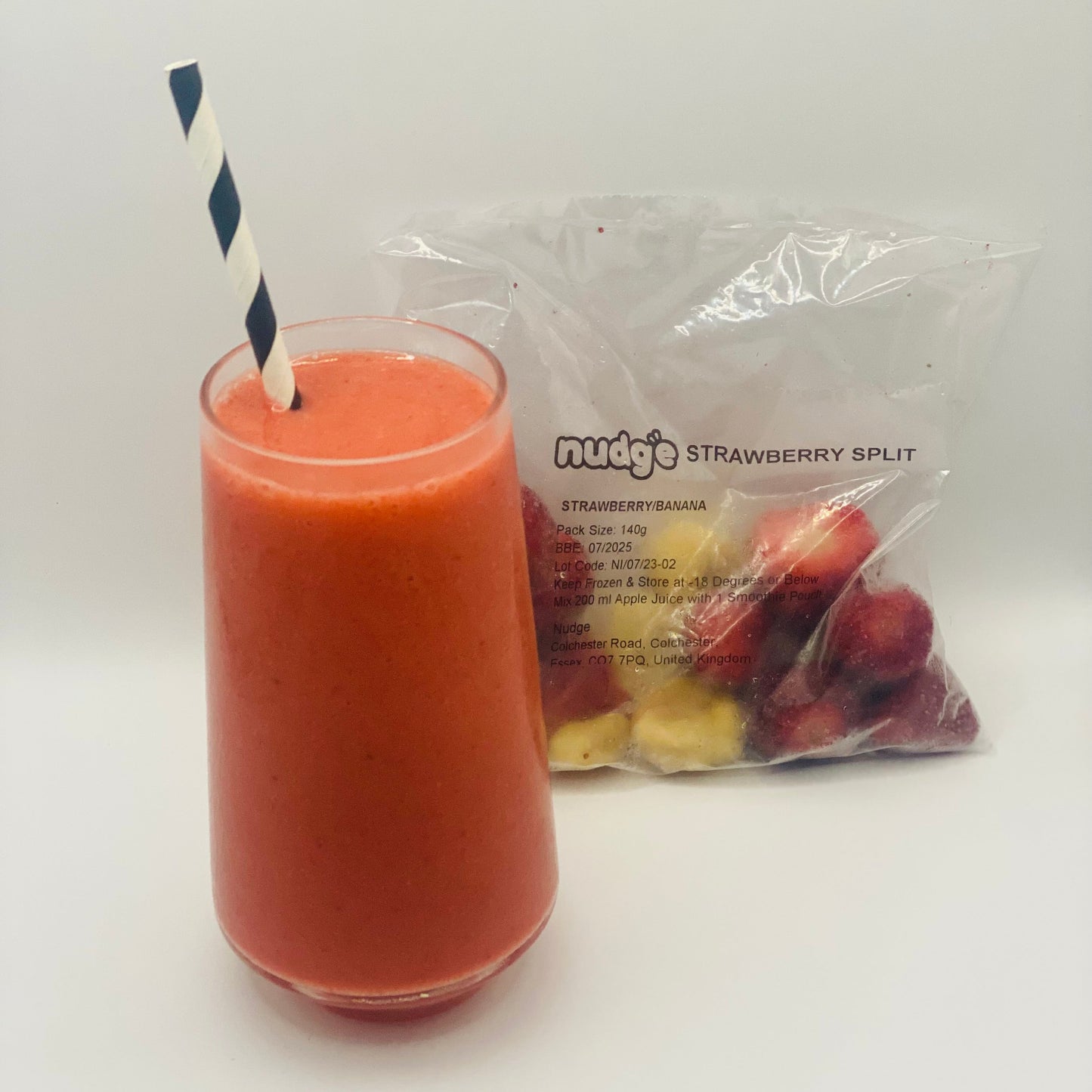 Nudge strawberry split frozen smoothie in glass with 140 gram sachet of strawberry and banana